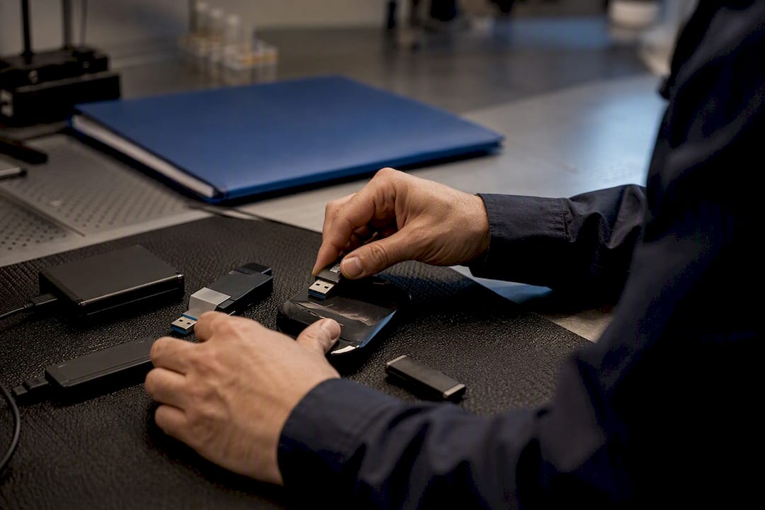 Court Admissible Cyber Intelligence for Lawyers and Counsel 1 Hands handling USB and external drives for investigation
